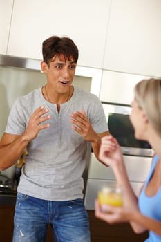 Enthusiastic about life. an enthusiastic young man chatting with his girlfriend in the kitchen.