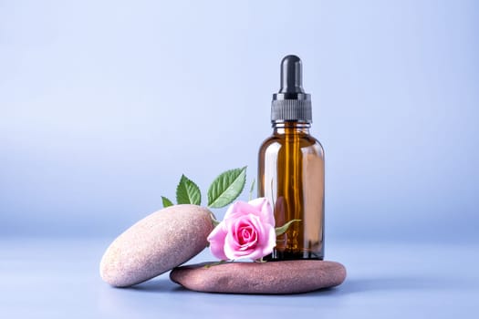 Glass bottle with pipette for a cosmetic product with a rose on stones