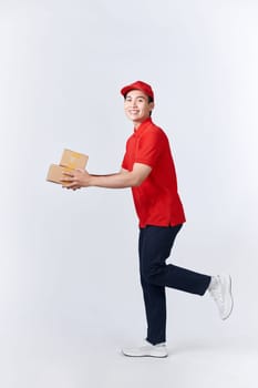 Work at post office. Courier in red uniform holding big parcel, free space, studio shot