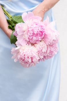 bride in a blue wedding dress with a bouquet of pink peonies, pastel paradise
