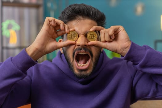 Indian man stock trader earning bitcoins, online monitoring trading operations mining hold BTC coins