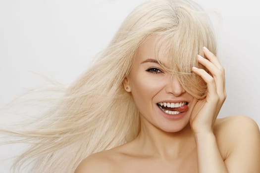 Beautiful woman with blond hair. Happy model face with long hairstyle