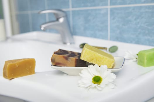 Craft organic soap bars on washbasin in the home bathroom. Purity. Hygiene. Home spa. Skin and body care concept
