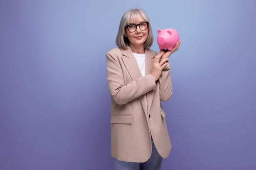 rich old woman with a piggy bank of money on a bright background with copy space