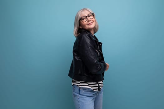 cheerful 60s mature woman in a stylish jacket on a bright background