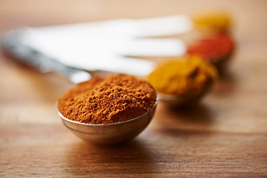 The perfect curry mix. Closeup shot of different spices in spoons.