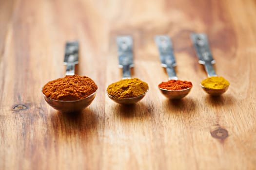 The curry spice range. Closeup shot of different spices in spoons.