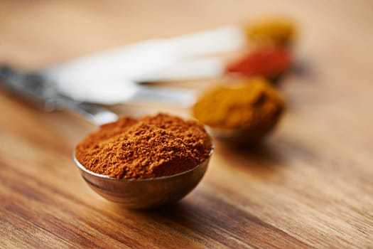 Add flavor to your curry dishes. Closeup shot of spices in spoons.