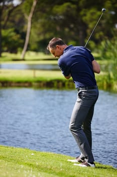 Swing while youre winning. a man taking a swing in a game of golf.