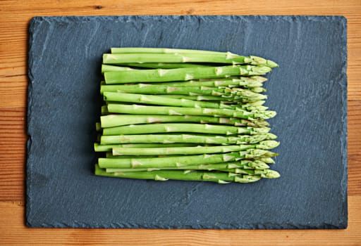 Its got powerful health benefits. fresh asparagus spread out on a tabletop.