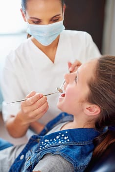 Your teeth are looking great. a female dentist and child in a dentist office.