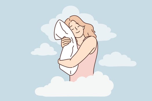 Joyful woman is sleeping and hugging pillow being among clouds symbolizing calmness and night dreams