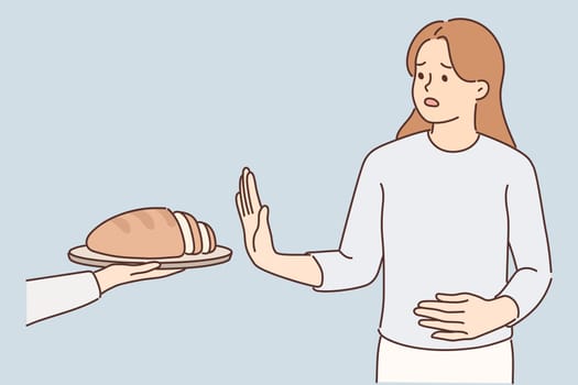 Frustrated woman holding on to stomach refuses bread due to allergies and gluten intolerance