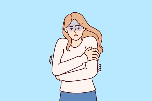 Freezing woman hugging shoulders trying to keep warm and feeling chills after contracting flu