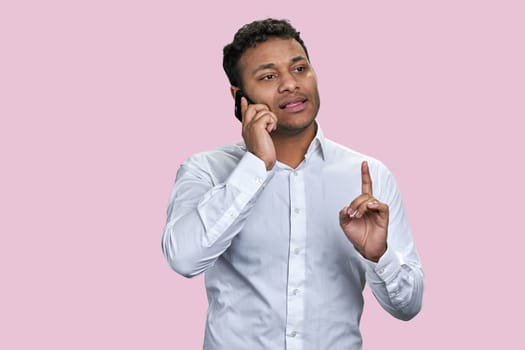 Portrait of a young indian businessman having phone conversation.