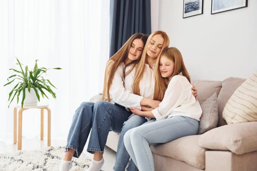 Closeness of the people. Young mother with her two daughters at home at daytime