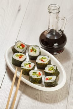Sushi rolls with rice, pieces of avocado, cucumber and lettuce leaves