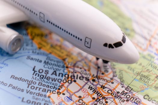Miniature passenger plane on a map of Los Angeles through selective focus, background blur