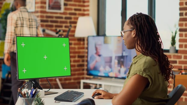 Corporate worker looking at greenscreen display on computer
