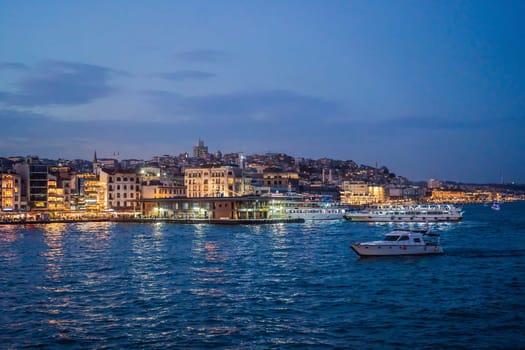 Istanbul at sunset, Turkey. Tourist boat sails on Golden Horn in summer. Beautiful sunny view of Istanbul waterfront with old mosque. Concept of travel, tourism and vacation in Istanbul and Turkey. Turkiye