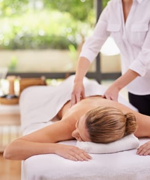 Experiencing total bliss. a woman in a day spa relaxing on a massage table