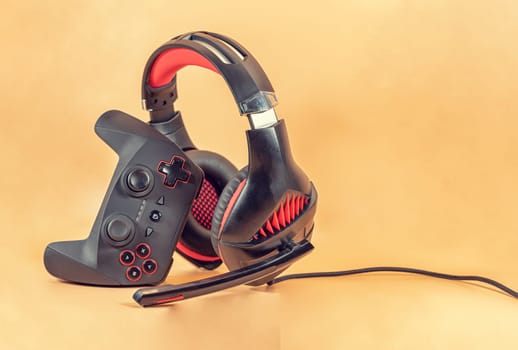 Background of the necessary accessories for the gamer: joystick and headphones with microphone
