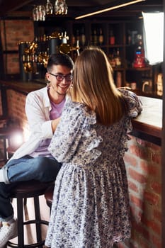 Cheerful young people in casual clothes sitting in the pub