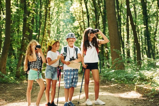 Weekend activies. Kids strolling in the forest with travel equipment