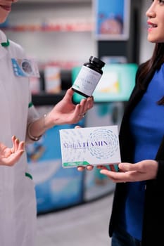 Woman choosing between multivitamin packages in drugstore