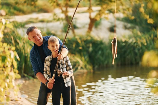 Father and son on fishing together outdoors at summertime