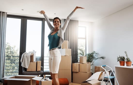 Ive upgraded. Cropped portrait of an attractive young woman standing with her arms outstretched while moving into a new house.