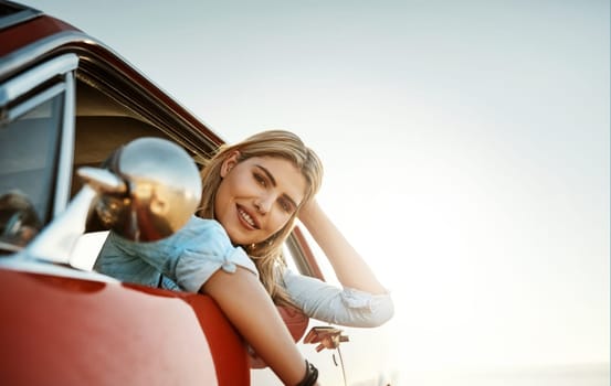 The ultimate summer activity, a road trip. Portrait of a beautiful young woman going on a summers road trip.