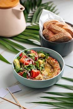 Portion of hummus bowl with fresh salad
