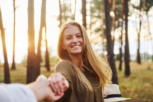 Happy couple is outdoors in the forest at daytime