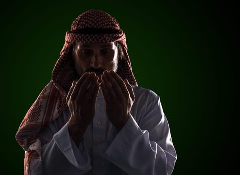Arab man in prayer with his palms in front of his face. It conveys the devotion and spirituality inherent in Islamic culture