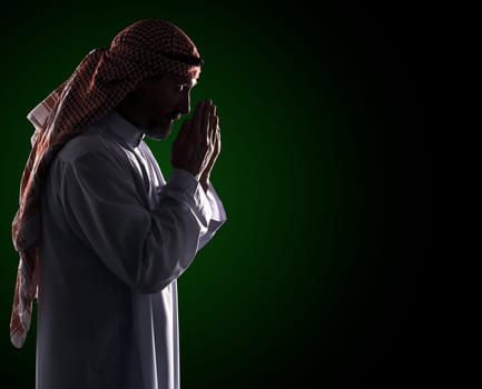 Islamic prayer ritual. Arab Man in Profile Holding Palms in Front of Face, Copy Space