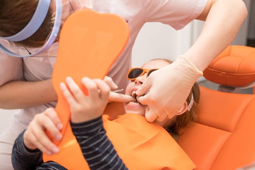 Dental plate. Expansion of the jaw in a child. teenage girl holding an orthodontic plate in her hands.orthodontic doctor examine teeth and gums of little girl jaw.dental concept, retainer for teeth