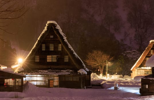 Traditional A-frame house in Gokayama amid snow and mist at night