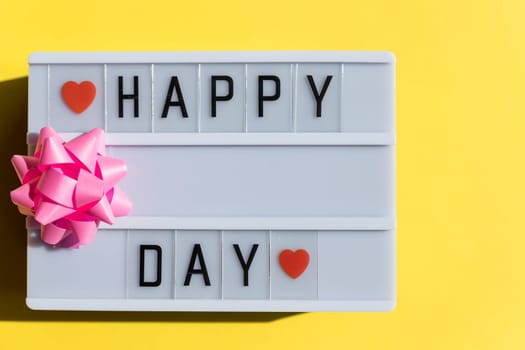 Happy day sign on light box on yellow backround.Happy Parents Day or International Day of Families.greeting card. Invitation for wedding.Stylish text frame lightbox with the inscription