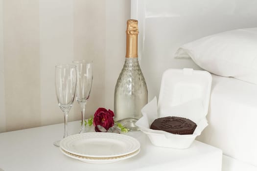 Two glasses with a bottle of champagne and a chocolate dessert in a luxury hotel room. Dating, romance, honeymoon, Valentine's day.