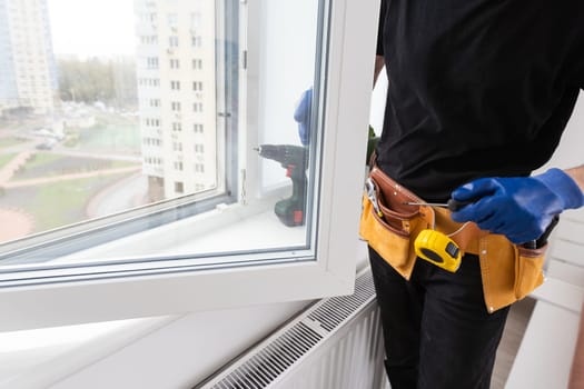 Close-up Of Young African Handyman In Uniform Installing Window