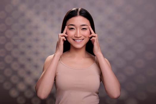 Skincare asian model showing eyes anti wrinkle massage procedure