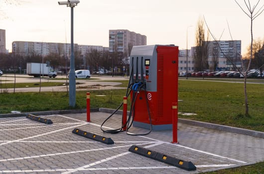 Charging station for electric vehicles, in the background the houses of a residential area of the city