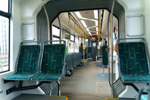 Interior design of a modern bus for passenger transportation in the city. A bus with blue seats and yellow guarantors. Public transport.