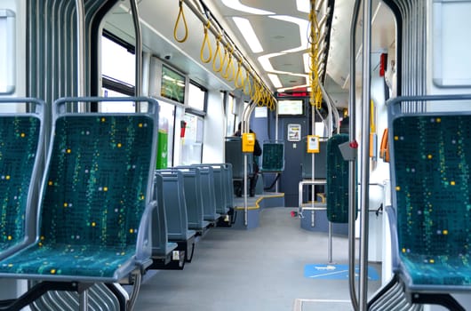 Interior design of a modern bus for passenger transportation in the city. A bus with blue seats and yellow guarantors. Public transport.
