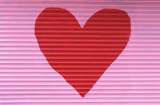 A large red heart is painted on the pink blinds.