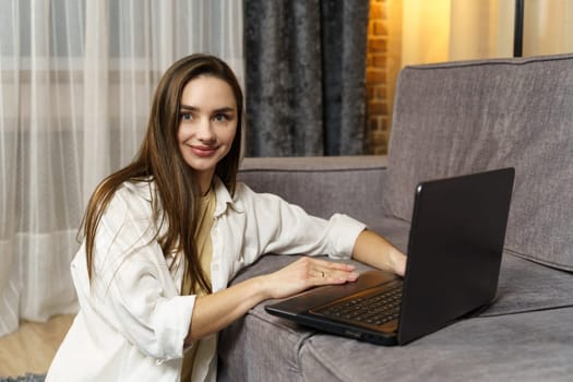 Beautiful young female freelancer working on a laptop at home.