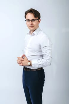 A man in a white shirt with glasses. Light background