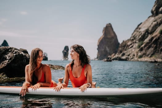 Woman sup yoga. Happy sporty woman practising yoga pilates on paddle sup surfboard. Female stretching doing workout on sea water. Modern individual female hipster outdoor summer sport activity.