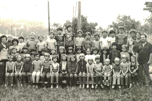 Retro photo of group of school pupils young pioneers with their teachers at summer camp. Black white photo